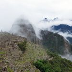 Machu Picchu with the mountains in the back covered in clouds