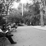 people chilling and reading in Madison park in New York city NYC USA photo in black and white
