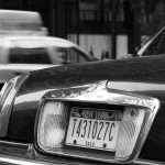 close up of a tag in new york city with a taxi in the back NYC USA black and white