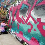 a young local artist painting in street art in Ghent