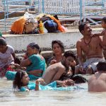 locals are bathing and having a good time in the Narmada river at Marble Rocks in India