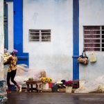 a woman carrying flowers in a street flower shop in la Havana Cuba