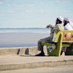 two muslim men sitting on a bench and watching the indian ocean in Beira Mozambique