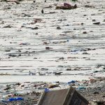 Kid looking at the Mumbai Versova beach in despair in front of so much plastic in 2011