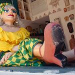 colorful dressed doll waring the colors of Brazil in the front of a store in the streets of Olinda