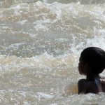 a child is swimming in the Narmada river at Marble Rocks Madhya Pradesh India