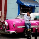 taxi driver of an old pink cuban car waiting by Callejon de Hamel for his customers in la Havana Cuba