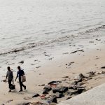 people walking in plastic on the Versova beach in Mumbai before the clean up activities