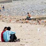 couple sitting on the Mumbai Versova beach in 2011 before the actions were taken to clean up this beach