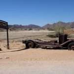 Abandoned car by the Welcome to Solitaire sign in the gas station in the middle of the desert in Namibia