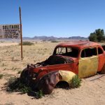 old yellow and red car, abandoned and rusted in the SOLITAIRE gas station in the middle of the desert in Namibia